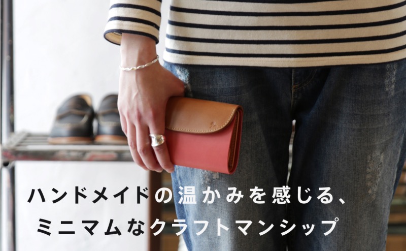 MOTOの男女で使えるピンクの財布を持つ人