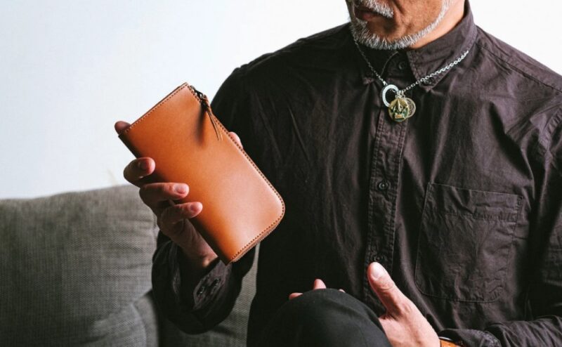 国産長財布SMITHカードが立つ日本製栃木レザーと手に取る男性