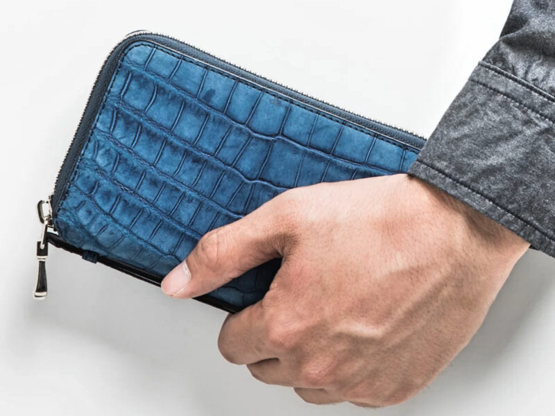 安心のエキゾチックレザー革財布を持つ男性